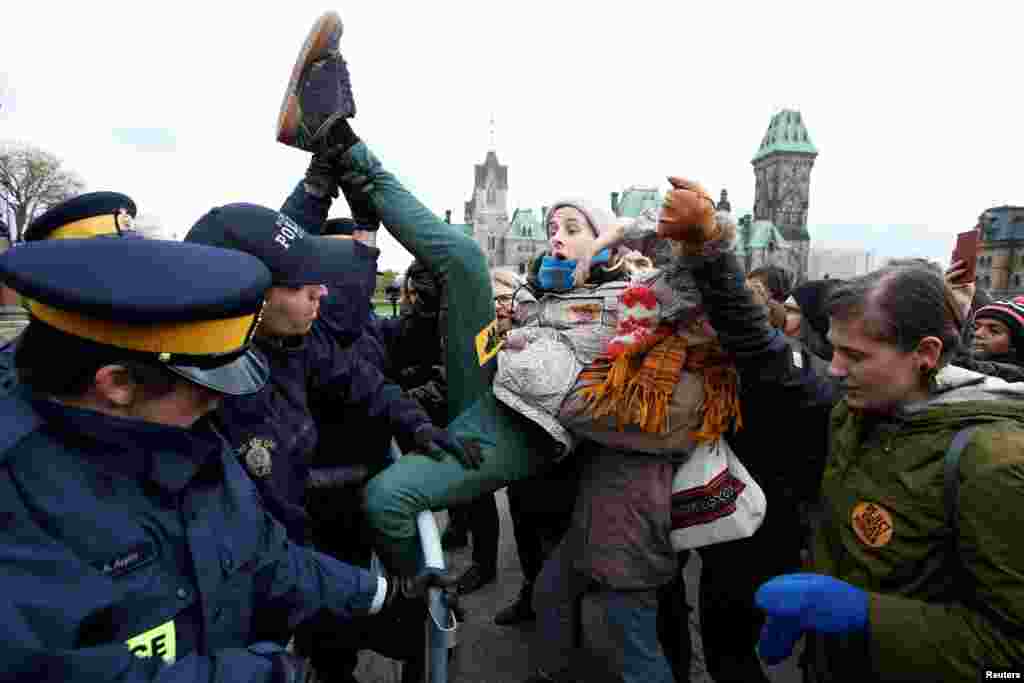 A protester struggles to cross a police barricade during a demonstration against the proposed Kinder Morgan pipeline on Parliament Hill in Ottawa, Ontario, Canada.