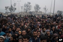 Displaced Iraqi men, fleeing fighting between Iraqi security forces and Islamic State militants, wait for a security check before being transferred to a camp on the western side of Mosul, Iraq, March 23, 2017.