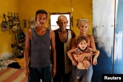 Zulay Pulgar, 43, holds her son Emmanuel, 4, next to her husband Maikel Cuauro, 30, and her father Juan Pulgar, 73, while they pose for a portrait in their house in Punto Fijo, Venezuela, Nov. 17, 2016.