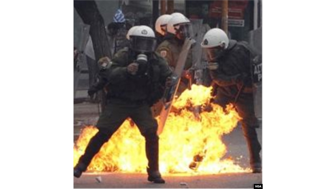 Polisi Yunani memadamkan bom-bom molotov yang dilemparkan oleh para demonstran.