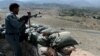 An Afghan security force member stands at a checkpoint, set alight by Islamic State fighters during overnight clashes, in the Achin district of eastern Nangarhar province, Sept. 28, 2015.