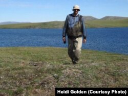 Study author Mark Urban walks back from field work in an Arctic lake where he is studying how climate change is affecting fish populations. (Credit: Heidi Golden)