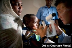 FILE - Screening of a pediatric patients by Dr. Donny Suh in Gondar, Ethiopia, Oct. 2012. Dr. Suh is a cataract and strabismus specialist from Des Moines, Iowa.