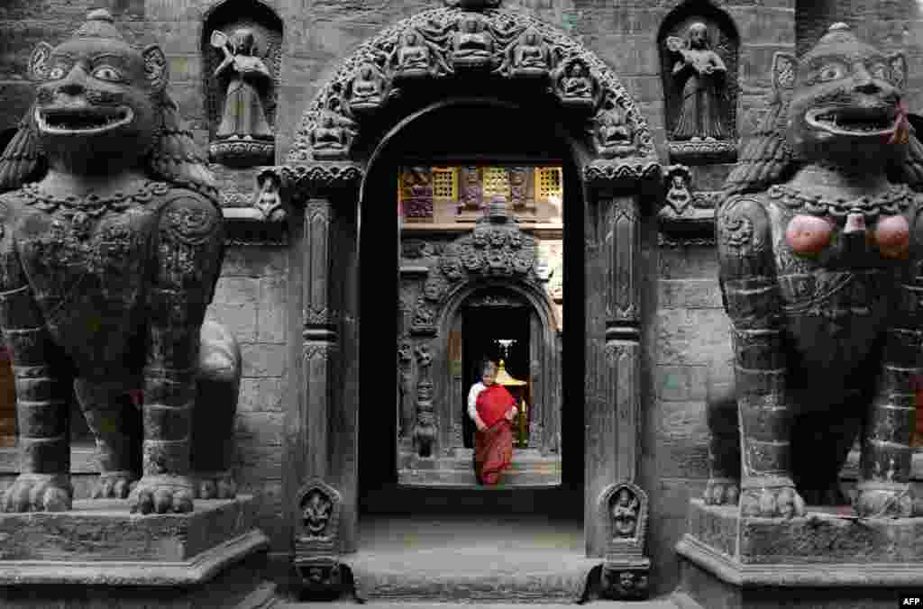 A Nepalese Buddhist devotee leaves the Golden Temple after offering prayers near Patan Durbar square in Lalitpur, about five kilometers southeast of Kathmandu.