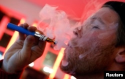 A customer puffs on an e-cigarette at the Henley Vaporium in New York City December 18, 2013. At the Henley Vaporium, one of a growing number of e-cigarette lounges sprouting up in New York and other U.S. cities, patrons can indulge in their choice of mor
