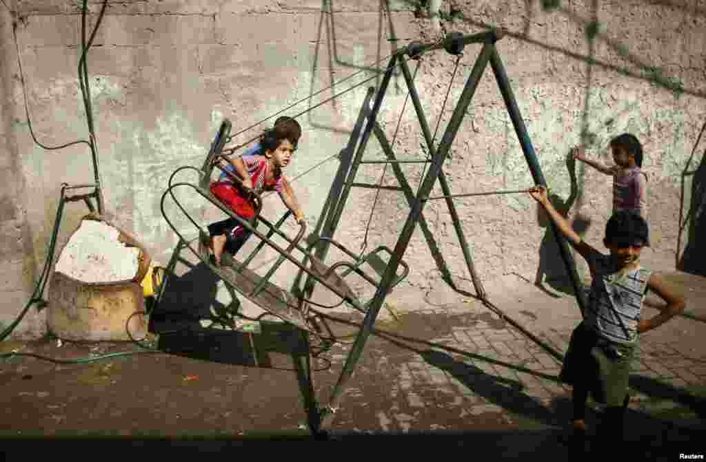 Palestinian children play on a swing in Jabaliya refugee camp in the northern Gaza Strip, Aug. 4, 2014.