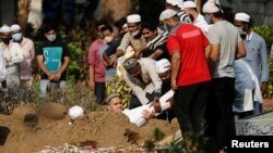 Pemakaman seseorang yang meninggal akibat COVID-19 di pemakaman muslim di Mumbai, India, 28 April 2021. (REUTERS / Francis Mascarenhas)
