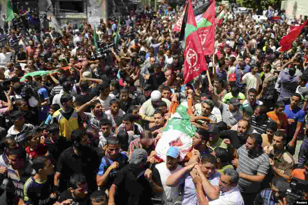 A crowd of Palestinians march during the funeral of the wife of Hamas&#39;s military leader, Mohammed Deif, his infant son Ali and other Palestinians whom medics said were killed in Israeli air strikes, in the northern Gaza Strip, Aug. 20, 2014.