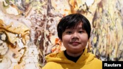 Xeo Chu, a young Vietnamese artist, stands in front of one of his pieces before his first solo show at the Georges Berges Gallery in New York City, New York, U.S., December 18, 2019. REUTERS/Shannon Stapleton