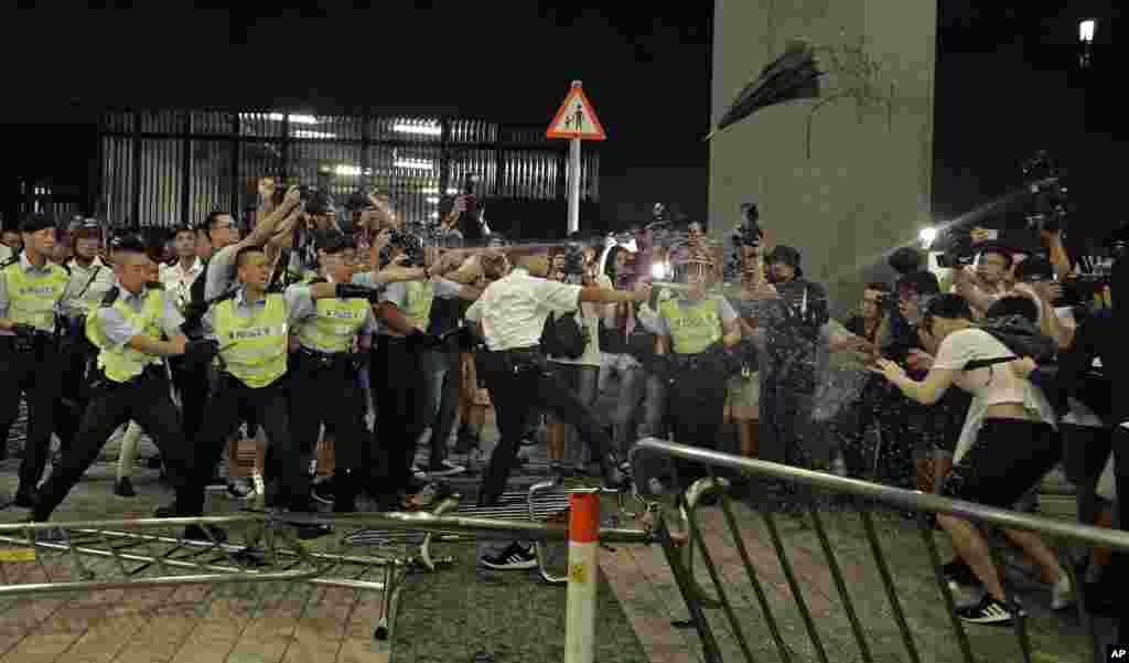 Police officers use pepper spray during a rally against a proposed extradition law at the Legislative Council in Hong Kong.