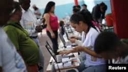 Venezuelans line up to cast their votes during a governors election in Caracas, December 16, 2012. 