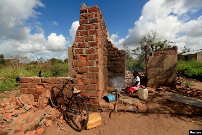 Ester Thoma cooks at her damaged house in the aftermath of Cyclone Idai, in the village of Cheia, which means "Flood" in Portuguese, near Beira, Mozambique April 1, 2019.