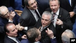 Senadores brasileños saludan a Michel Temer (centro) a su arribo al Congreso para prestar juramento como presidente de Brasil, el miércoles, 31 de agosto de 2016.