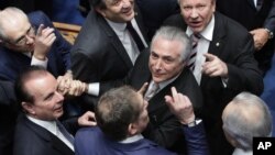 Senators greet Brazil's Michel Temer, center, as he arrives to take the presidential oath at the National Congress in Brasilia, Brazil, Aug. 31, 2016.