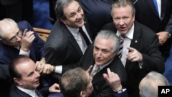 Senators greet Brazil's Michel Temer, center, as he arrives to take the presidential oath at the National Congress in Brasilia, Brazil, Aug. 31, 2016.