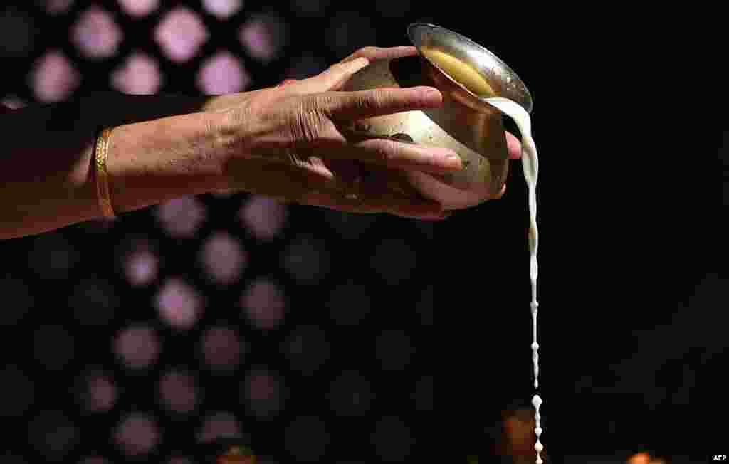 A Kashmiri Pandit pours milk onto statues of Hindu gods during the annual Hindu festival at the Khirbhawani temple in the village of Tullamulla, some 30 kms east of Srinagar. Hundrends of Kashmiri Hindus, many of whom were displaced more than two decades ago, attended the festival to worship the Hindu goddess Mata Khirbhawani.