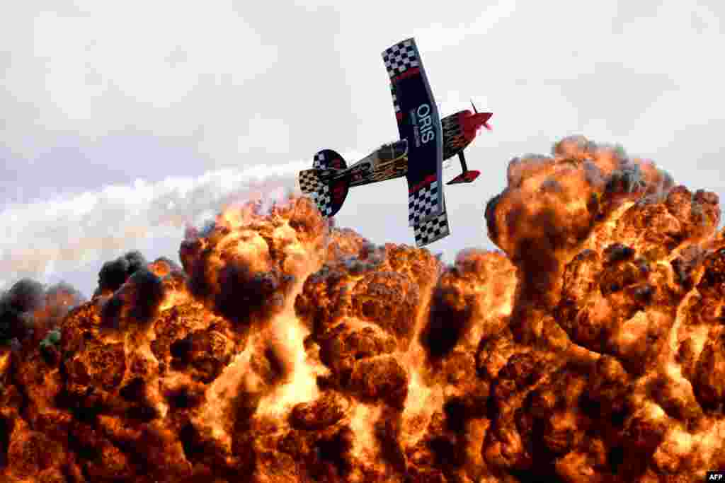 A member of the Tinstix of Dynamite aerobatics team flies in front of a wall of fire during the Australian International Airshow in Melbourne.