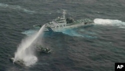 In this photo released by Japan Coast Guard 11th Regional Headquarters, a Japanese Coast Guard patrol boat uses water cannon to warn a Taiwanese leisure boat, left, and a Taiwanese Coast Guard boat off Uotsuri in Japanese and Diaoyu Dao in Chinese, January 24, 2013.