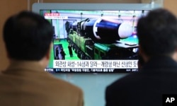 People watch a TV screen showing a local news program reporting about North Korea's missile launch, at the Seoul Railway Station in Seoul, South Korea, Nov. 30, 2017.