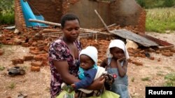 짐바브웨 치마니마니 지역에서 열대성 저기압 사이클론 '이다이'의 영향으로 집을 잃은 가족이 길 위에 서 있다. 