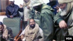 Una fotografía tomada por uno de los guardias en Zintan, muestra a Saif al-Islam Gadhafi rodeado por sus captores en el aeropuerto de Obari.