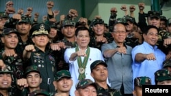 Philippines President Rodrigo Duterte (C) clenches fist with members of the Philippine Army during his visit at the army headquarters in Taguig city, metro Manila, Philippines October 4, 2016. (REUTERS/Romeo Ranoco)