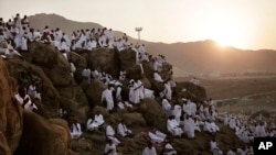 Muslim pilgrims pray on a rocky hill known as Mountain of Mercy, on the Plain of Arafat, during the annual hajj pilgrimage, ahead of sunrise near the holy city of Mecca, Saudi Arabia, Sept. 11, 2016.