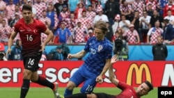Le Croate Luka Modric en action contre les Turcs Oguzhan Ozyakup (droite) and Ozan Tufan (gauche), Paris, France, 12 juin 2016. 