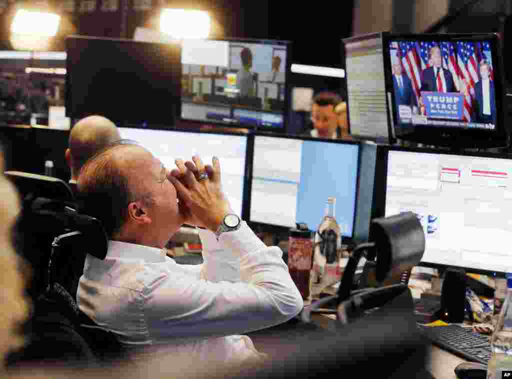 A broker reacts while watching U.S. President-elect Donald Trump delivering his victory speech, on a television screen at the stock market in Frankfurt, Germany.