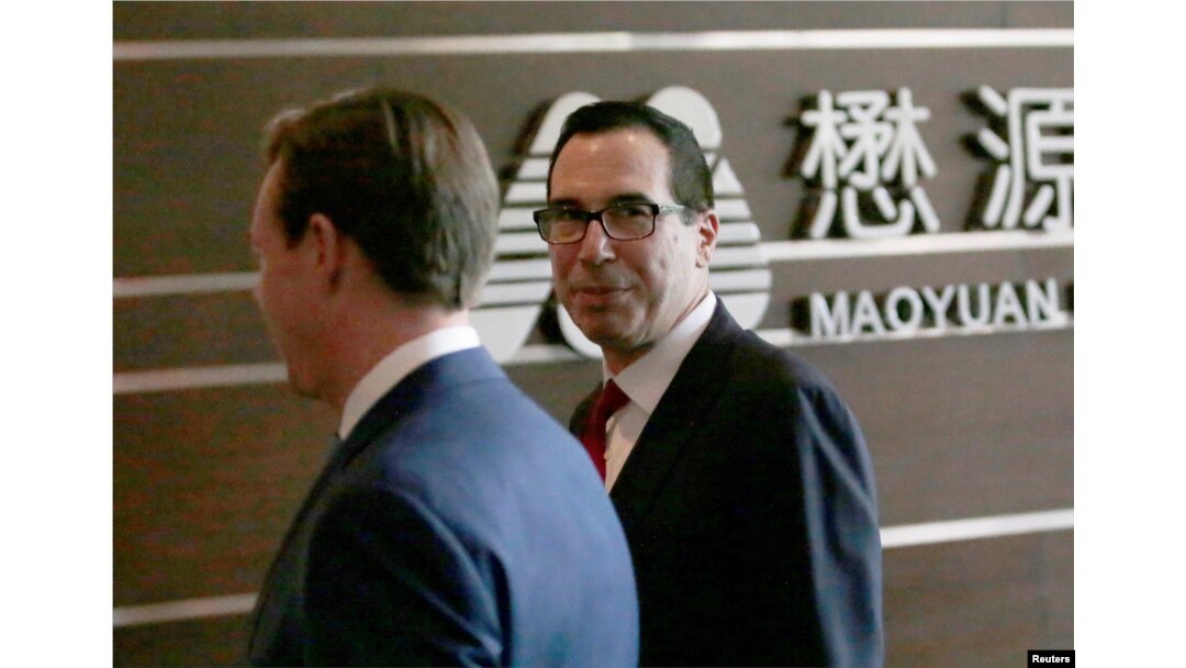 FILE - U.S. Treasury Secretary Steven Mnuchin, right, and a U.S. delegation arrive at a hotel in Beijing for trade talks with China, May 3, 2018.