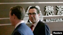 FILE - U.S. Treasury Secretary Steven Mnuchin, right, arrives at a hotel in Beijing for trade talks with Chinese officials, May 3, 2018.