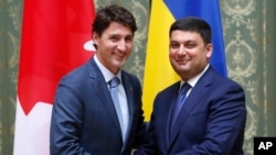 Canadian Prime Minister Justin Trudeau (L) and Ukraine's Prime Minister Volodymyr Groysman shake hands during a meeting in Kiev, Ukraine, July 11, 2016. 