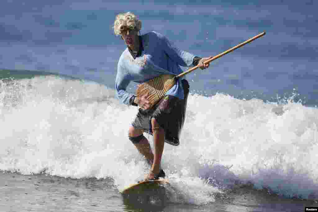 David Nickerson dressed as Mrs. Doubtfire rides a wave during the 7th annual ZJ Boarding House Haunted Heats Halloween surf contest in Santa Monica, California, USA, Oct. 25, 2014.