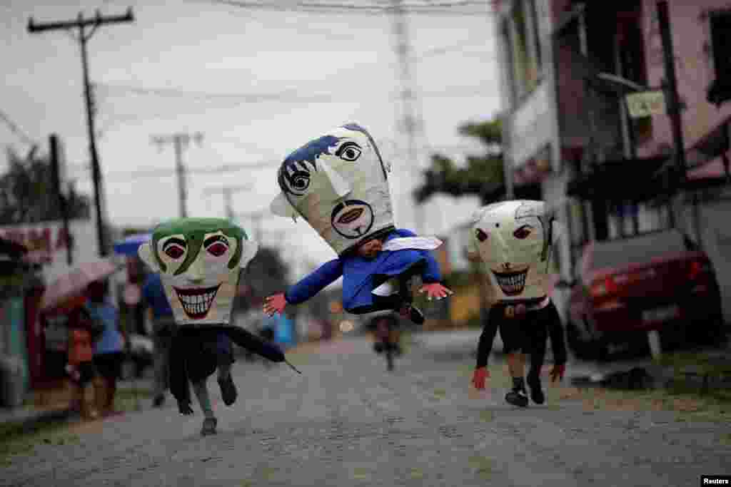 Members of the "Group Boi Faceiro" wear masks known as "Cabecudos" and take part in carnival festivities in Sao Caetano de Odivelas, Brazil, Feb. 13, 2018.