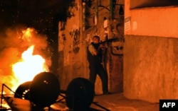 FILE - A military policemen stands in position during a violent protest in a favela next to Copacabana, Rio de Janeiro, April 22, 2014.