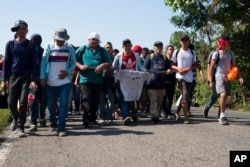 Central American migrants, part of a caravan hoping to reach the U.S. border, walk on a road in Frontera Hidalgo, Mexico, April 12, 2019. The group pushed past police guarding the bridge and joined a group of about 2,000 migrants walking toward Tapachula.