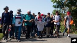 Central American migrants, part of a caravan hoping to reach the U.S. border, walk on a road in Frontera Hidalgo, Mexico, April 12, 2019. The group pushed past police guarding the bridge and joined a group of about 2,000 migrants walking toward Tapachula.