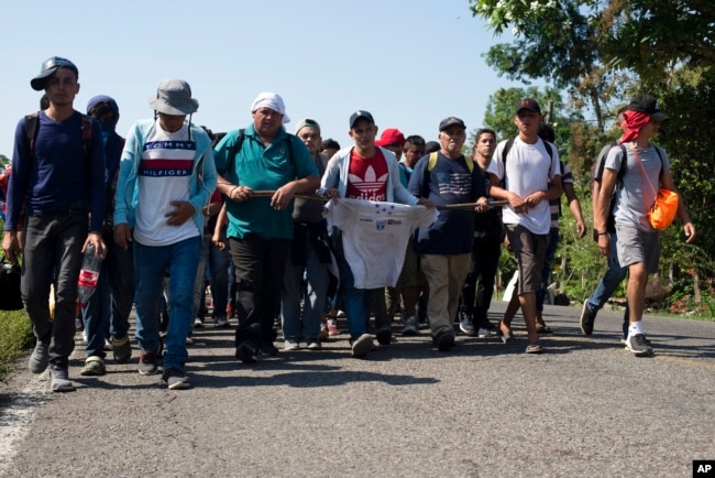 Central American migrants, part of a caravan hoping to reach the U.S. border, walk on a road in Frontera Hidalgo, Mexico, April 12, 2019. The group pushed past police guarding the bridge and joined a group of about 2,000 migrants walking toward Tapachula.