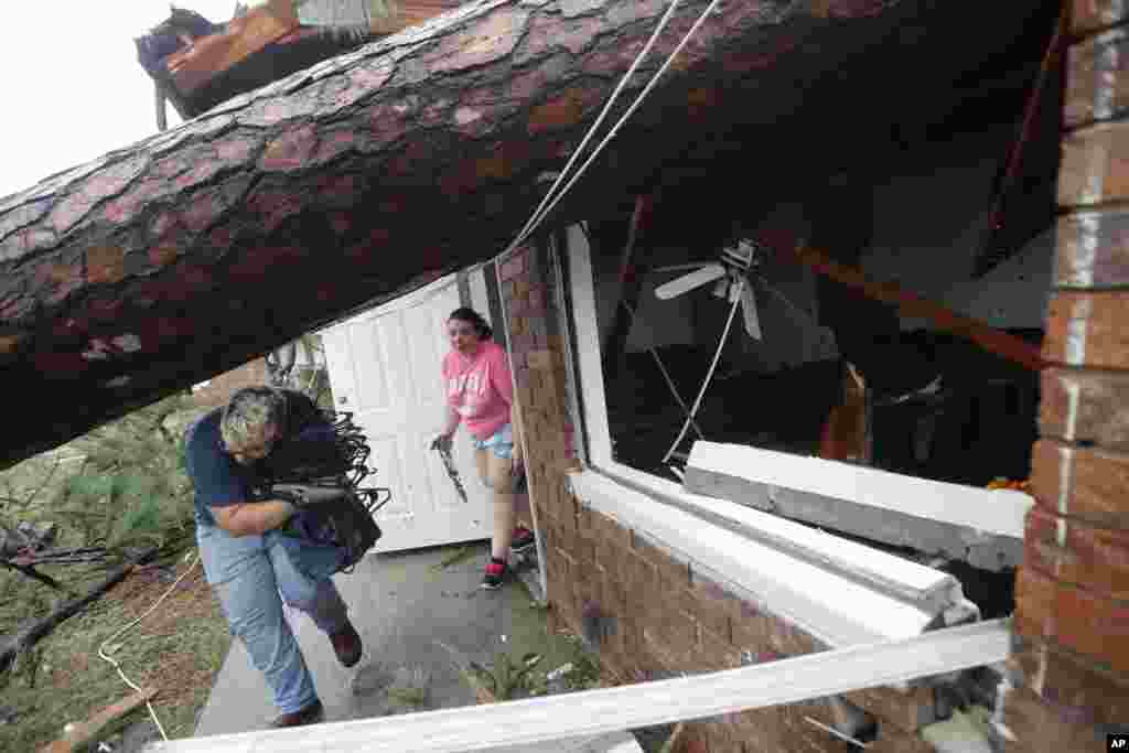 Megan Williams, left, and her roommate Kaylee O&#39;Brian take belongings from their destroyed home after several trees fell on the house during Hurricane Michael in Panama City, Florida, Oct. 10, 2018.