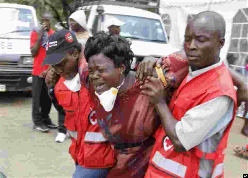 Red Cross personnel console a woman after she viewed the body of a relative killed in last week&#39;s attack at a university in Garissa, northeastern Kenya, at Chiromo funeral home, Nairobi, April 7, 2015.