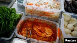 Korean style pickled cabbage, or Kimchi, and Chinese style pickled vegetables, or Pao Cai, are seen at a supermarket, in Beijing, China December 1, 2020. (REUTERS/Thomas Peter)