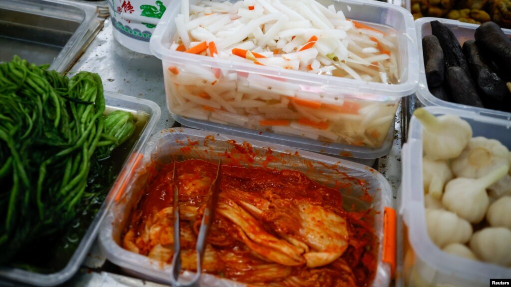 FILE - Korean style pickled cabbage, or Kimchi, and Chinese style pickled vegetables, or Pao Cai, are seen at a supermarket, in Beijing, China December 1, 2020. (REUTERS/Thomas Peter)