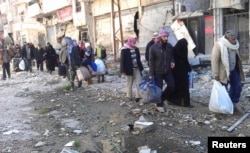 叙利亚平民携带着行李从被围困的霍姆斯撤出
