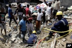 Emergency services attend the scene after a building collapsed in Lagos, Nigeria, March 13, 2019.