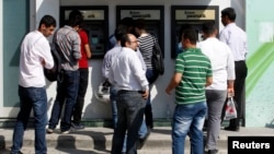 People line in front of automated teller machines in Hatay, Turkey, May 17, 2013. 