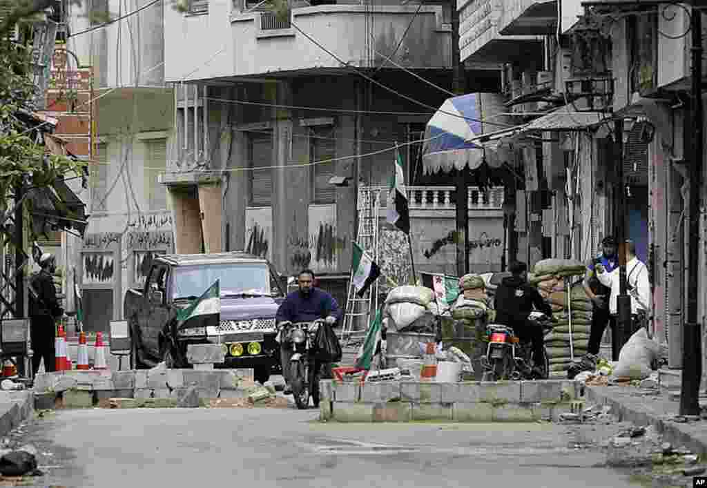 Syrian rebels man a checkpoint in the Khalidiya district of the central Syrian city of Homs, May 3, 2012. (AFP)