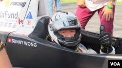 Sunny Wong in the PS Racing car, with ChildFund International decals behind, Sept. 15, 2013.