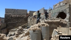 Members of the federal police walk in a destroyed building at Bab al Jadid district in the old city of Mosul, Iraq, June 1, 2017.