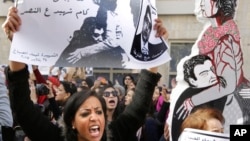 An Egyptian protester chants anti-Interior Ministry slogans as she holds a poster of Shaimaa el-Sabagh, an activist who was shot dead at a peaceful protest last Saturday, with Arabic that reads, "How many martyrs remaining for victory."