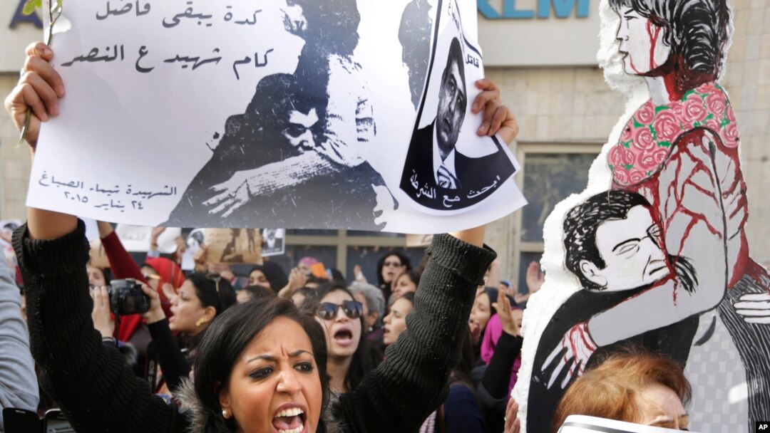 An Egyptian protester chants anti interior ministry slogans as she holds a poster of Shaimaa el-Sabagh, an activist who was shot dead at a small peaceful protest last Saturday, with Arabic that reads, " how many martyrs remaining for victory," during a wo